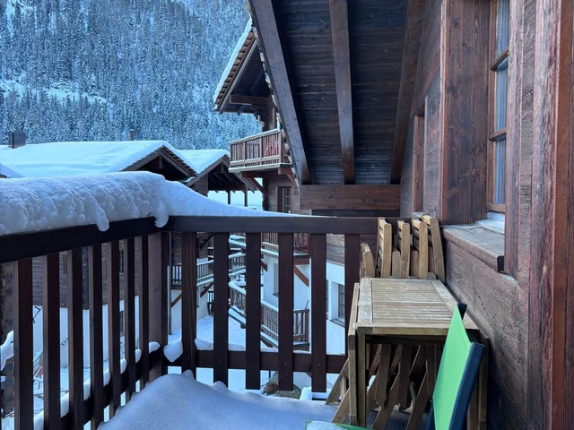 Balcon avec une petite table et 4 chaises pliables